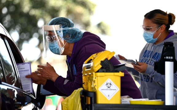 AUCKLAND, NEW ZEALAND - SEPTEMBER 25: A nurse hands out information after vaccinating a member of the public in their car during the Cook Islands drive through vaccination community event on September 25, 2021 in Auckland,
