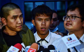 Thai rapper Thanayut Na Ayutthaya (C) better known as "Elevenfinger" speaks to the press next to other defendants, arrested after taking part in pro-democracy protests, following their release on bail outside the Criminal Court in Bangkok on August 20, 2020. -