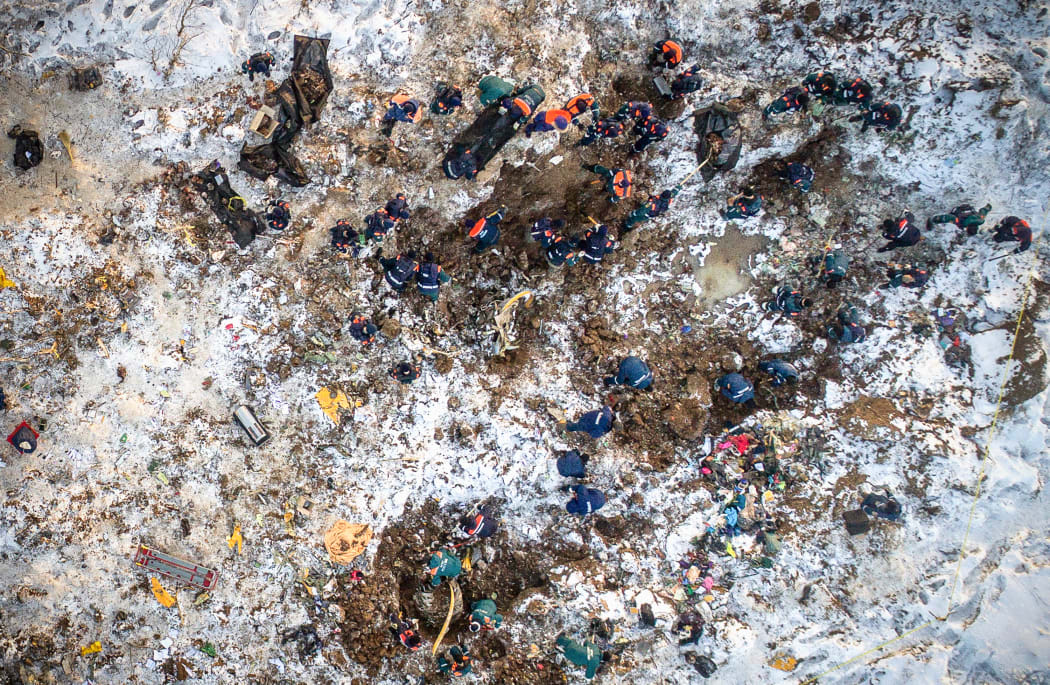 Emergency rescuers working at the site of the plane crash search through deep snow after the Russian passenger plane crashed in the Ramensky district near Moscow.