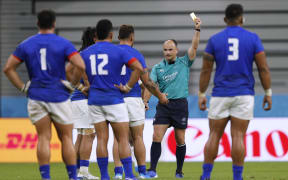 South African referee Jaco Peyer shows TJ Ioane (obscured) a yellow card.