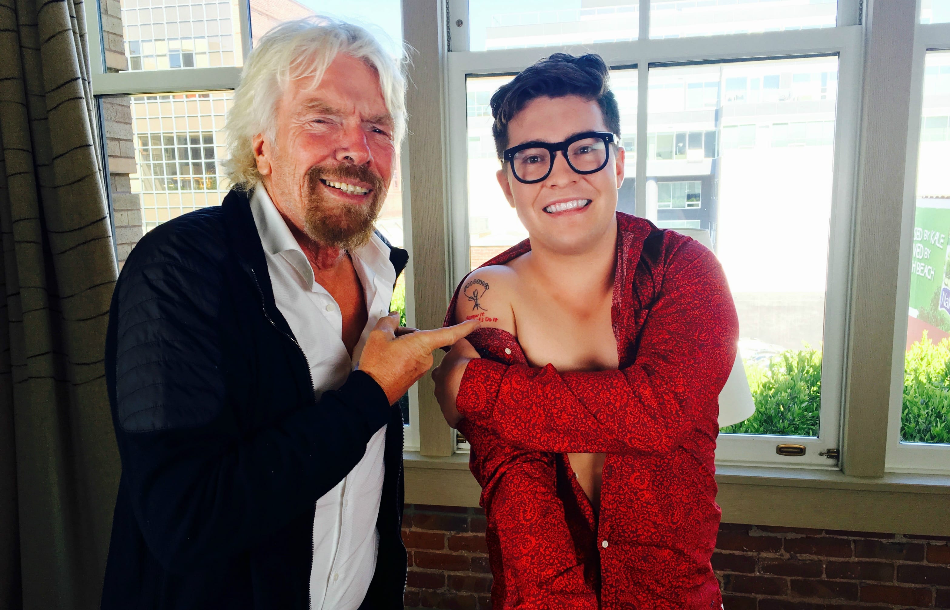 Jake Millar shows Richard Branson his tattoo. "The tattoo is a replica of a parachute my late father drew on my 10th birthday card. Underneath the parachute, it says 'Screw It, Let's Do It,' which is one of Richard's main quotes."