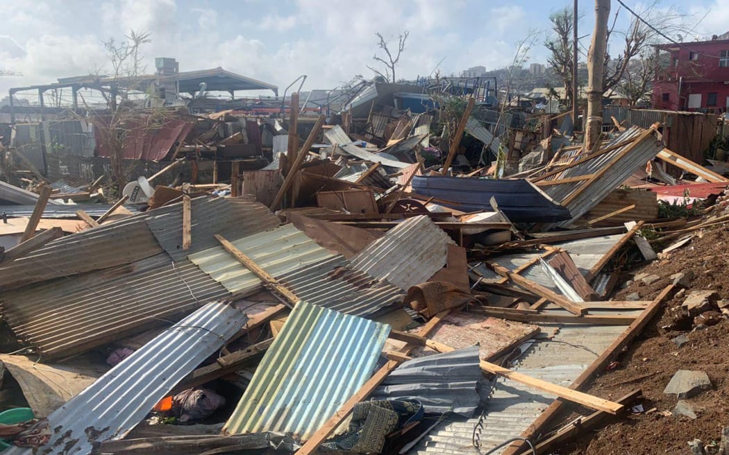 A photo taken on December 15, 2024 shows a pile of debris of metal sheets and wood after the cyclone Chido hit France's Indian Ocean territory of Mayotte. - At least 14 people were killed in Mayotte when a fierce cyclone battered the French Indian Ocean territory, authorities said on December 15, 2024, with officials warning it will take days to know the full toll. (Photo by KWEZI / AFP)