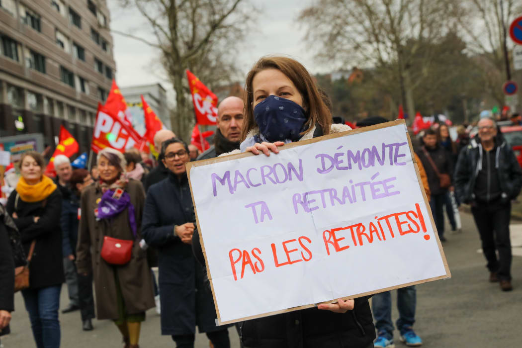 Demonstrators hold sign and flag fron Trade Unions during a demonstration in Lille.