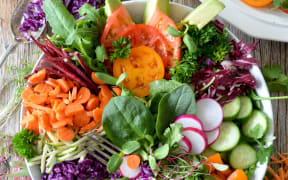 A bowl of fresh salad vegetables.