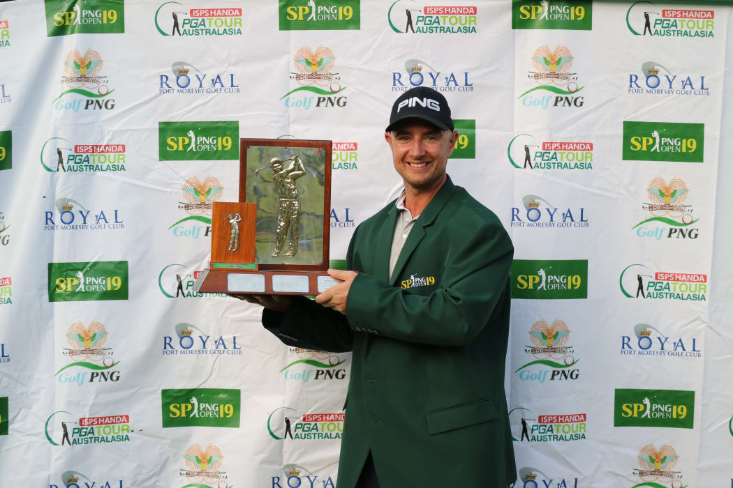 Peter Cooke lifts the PNG Open trophy.