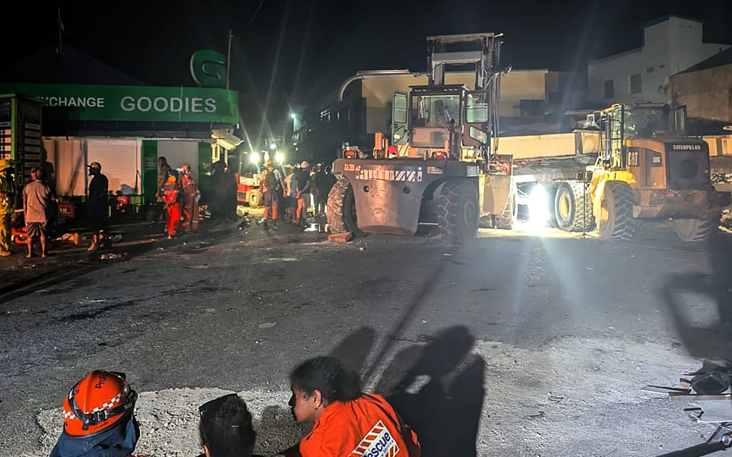 Rescue workers are seen at the site of a collapsed building after an earthquake struck Port Vila, the capital city of Vanuatu, on December 18, 2024. - Rescue teams dug for survivors trapped in crumpled buildings in the Pacific nation of Vanuatu on December 18 after a powerful earthquake killed at least 14 people, some of them buried in rubble and landslides. (Photo by AFP)