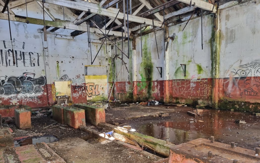A derelict coolstores building on the banks of the Pātea River in Taranaki.