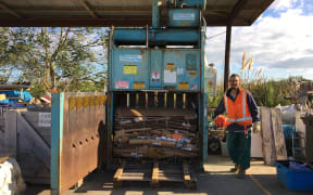 Giosuè Bima, one of the volunteers at the recycling centre standing next to the high density baler machine.