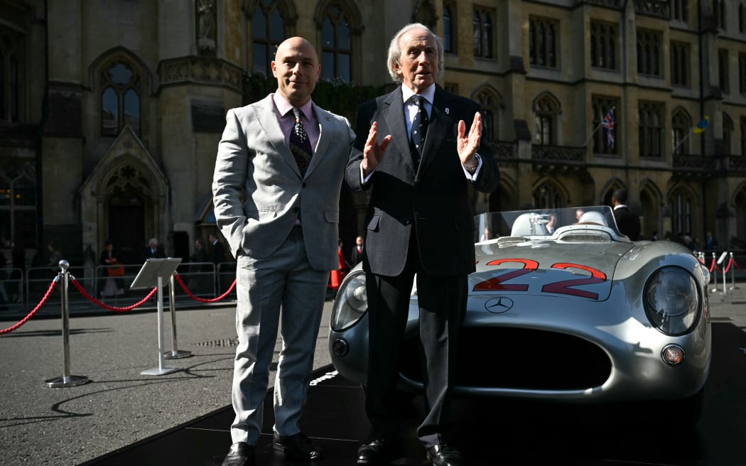 Elliot Moss, son of late British Formula One driver Stirling Moss, poses with Scottish former driver Jackie Stewart in front of a Mercedes Benz SLR 722, outside Westminster Abbey, central London, on May 8, 2024 ahead of a service of Thanksgiving for his father.