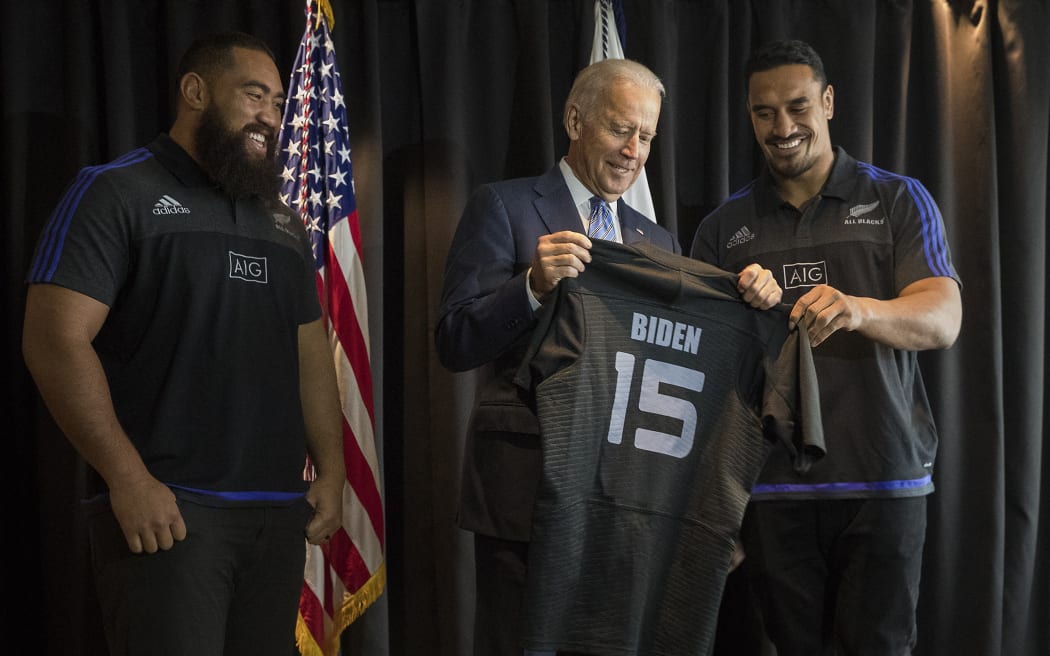 US Vice President Joe Biden (C) receives a personalised All Black rugby jersey from players Jerome Kaino (R) and Charlie Faumuina (L) during his visit to Auckland on July 21, 2016. Biden joked he was ready to play for the All Blacks as players from the world champion rugby side met with him during his visit.