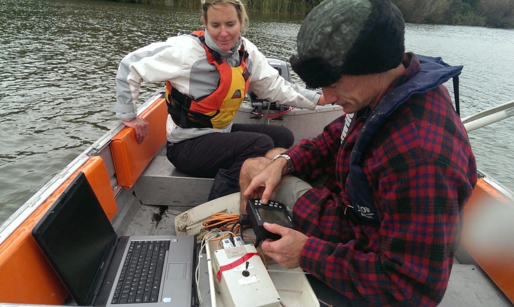 Dr Susie Wood and Professor David Hamilton measure concentrations of cyanobacteria on the lake's surface.