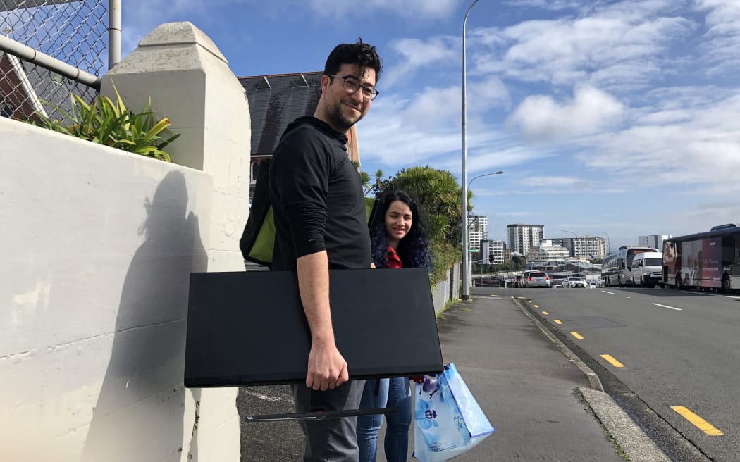 Software company worker Arash takes his monitor and other office supplies home.