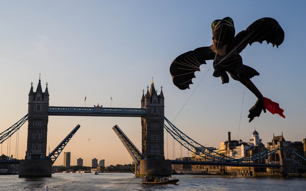 Jeff Moore 01/062014
This Picture is Free to use for editorial purposes relating to
 "HOW TO TRAIN YOUR DRAGON 2"

TOOTHLESS SOARS THROUGH THE TOWER BRIDGE OF LONDON
London’s Tower Bridge raised its drawbridge at 6am Tuesday 1st July for Toothless, the star of How To Train Your Dragon 2 to pass through its arches. Toothless the kite measuring  54ft flew down the Thames  through the raised drawbridge of the world famous landmark in celebration of the films release on Friday 11th July.

The kite measures 54ft from head to toe with a wingspan of 36ft (bigger than a London Double Decker bus) expertly flown by six trained kite flyers. 

Insert actual photo of Tootheless fly through:
The thrilling second chapter of the epic HOW TO TRAIN YOUR DRAGON trilogy returns to the fantastical world of the heroic Viking Hiccup and his faithful dragon Toothless.  The inseparable duo must protect the...