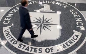 A man walking across the Central Intelligence Agency (CIA) logo in the lobby of CIA Headquarters in Langley, Virginia.