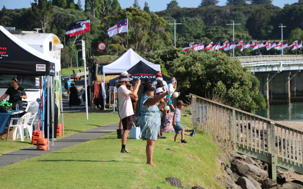 Spectators cheer as kaihoe paddle on the moana at Waitangi.