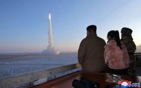 This undated picture released by North Korea's official Korean Central News Agency (KCNA) on 19 December, 2023 shows North Korean leader Kim Jong Un (left) and his daughter watching the test launch of a Hwasongpho-18 intercontinental ballistic missile (ICBM) at an undisclosed location in North Korea.