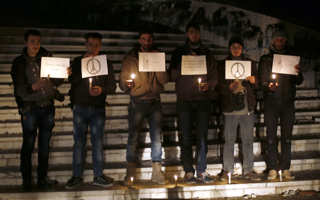 Syrians pay respect to the victims of the attacks in Paris, on November 14, 2015, in the eastern Ghouta area, a rebel stronghold east of the capital Damascus.