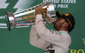 Lewis Hamilton celebrates on the winners podium.