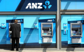 A man withdraws money from an ATM at the global headquarters of the Australia and New Zealand (ANZ) Bank in Melbourne on February, 2012.