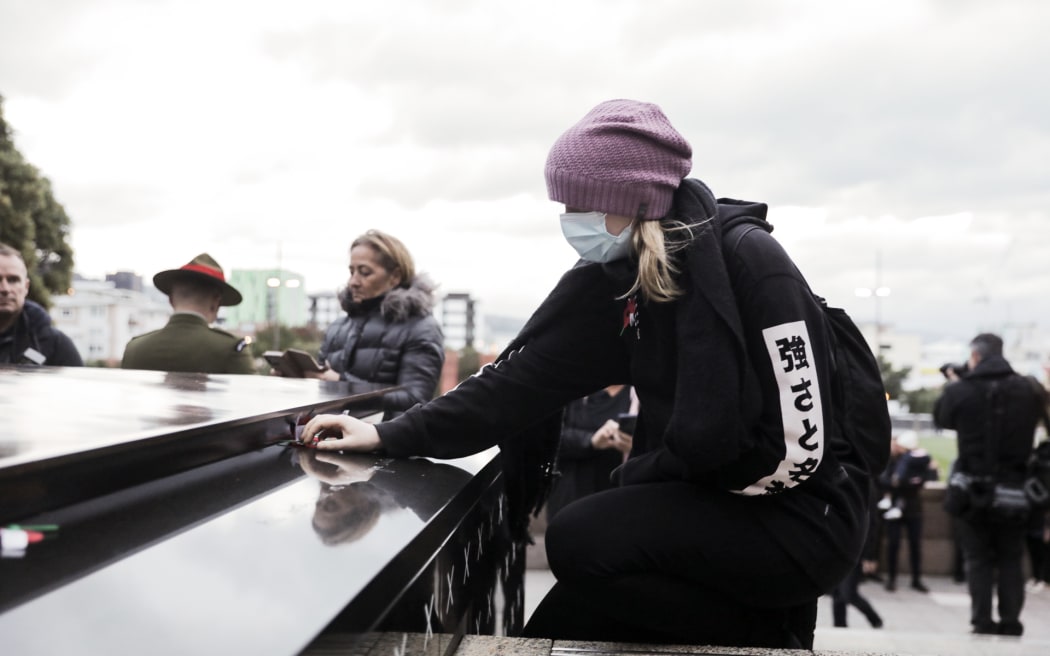 A person lays a poppy at the dawn service in Wellington