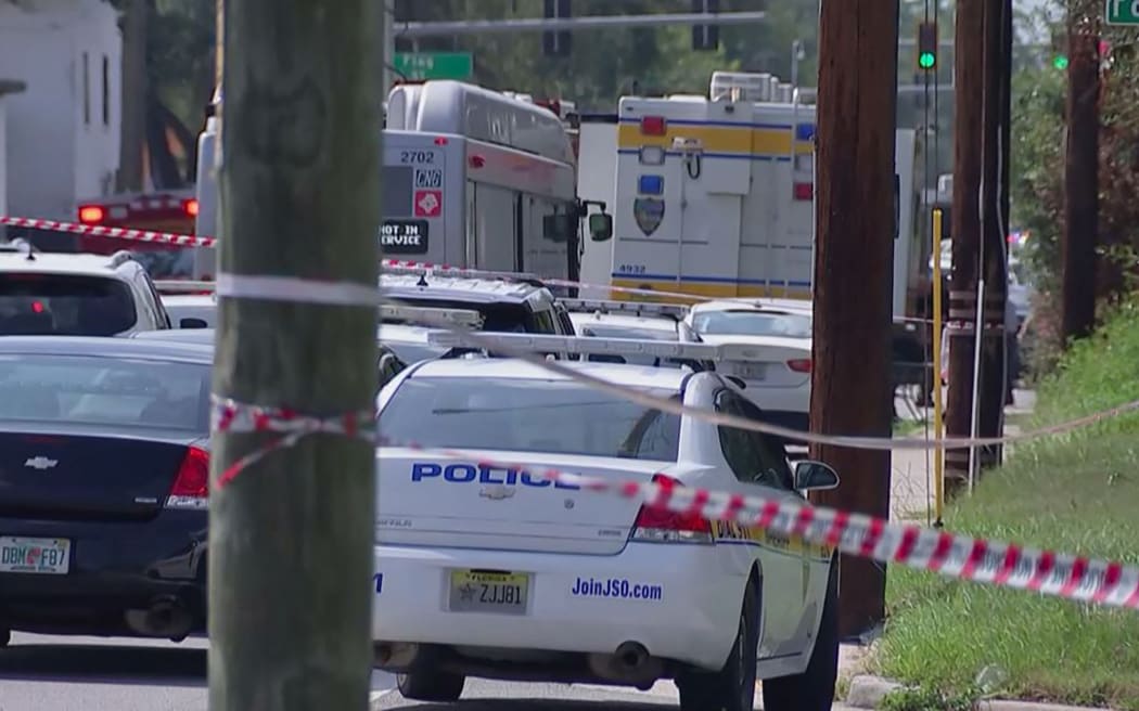 This video grab shows police cars on the site of a shooting in Jacksonville, Florida, 26 August, 2023. A white man driven by racial hatred shot dead three Black people in a Florida discount store on August 26 before taking his own life after a standoff with police, authorities said.