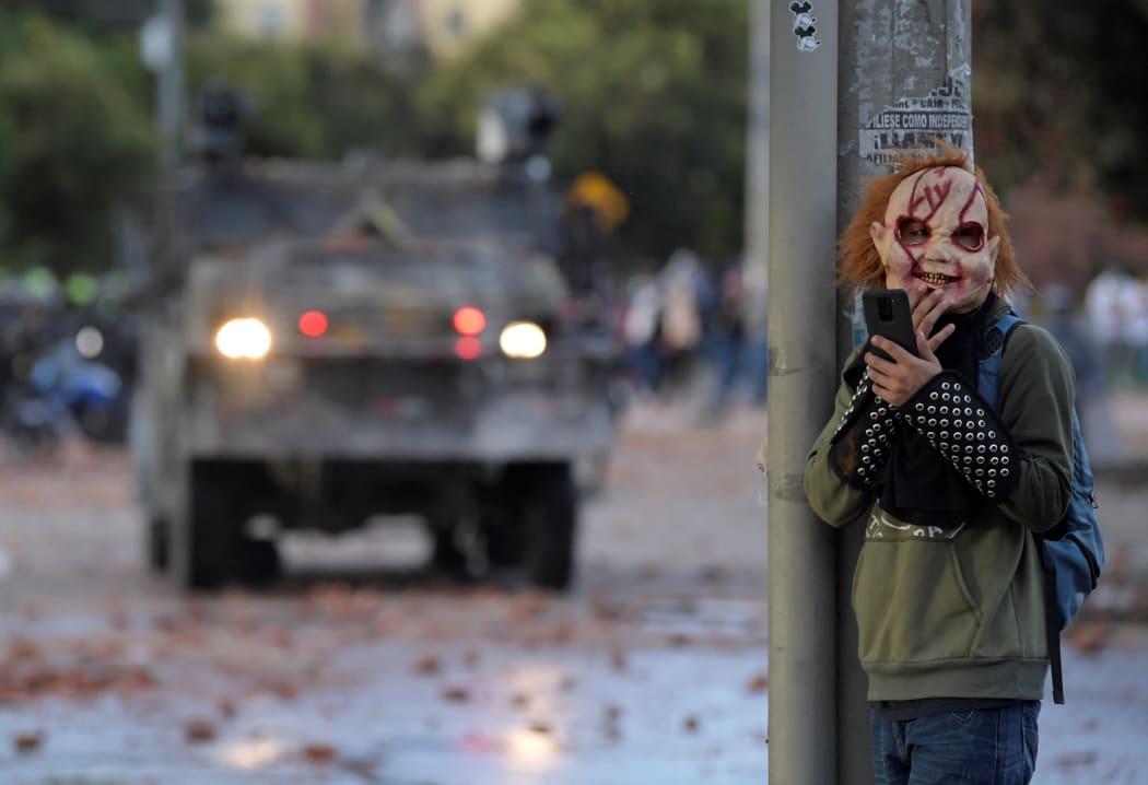 A demonstrator wearing a mask stands behind a column during clashes with riot police which erupted during the protest against the government of Colombian President Ivan Duque, in Suba neighbourhood, Bogota yesterday.