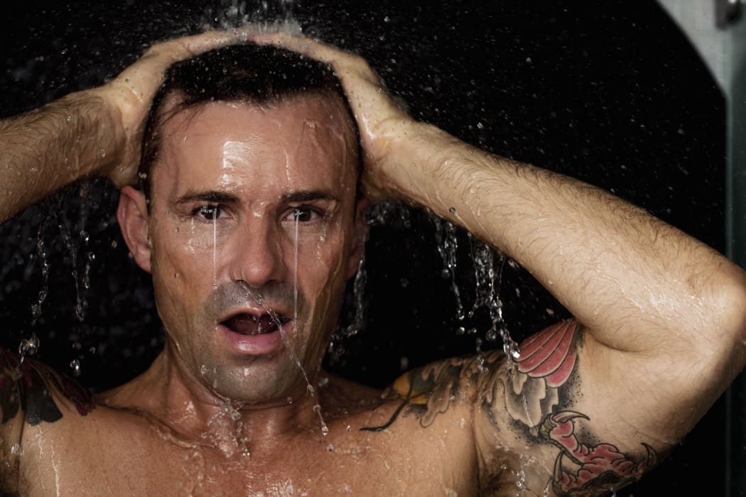 Man washing his hair in shower (Photo by Robin Skjoldborg / Cultura Creative / Cultura Creative via AFP)