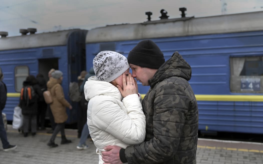 A couple embrace as they stand in front of an evacuation train at the central train station in Odessa on 6 March, 2022.