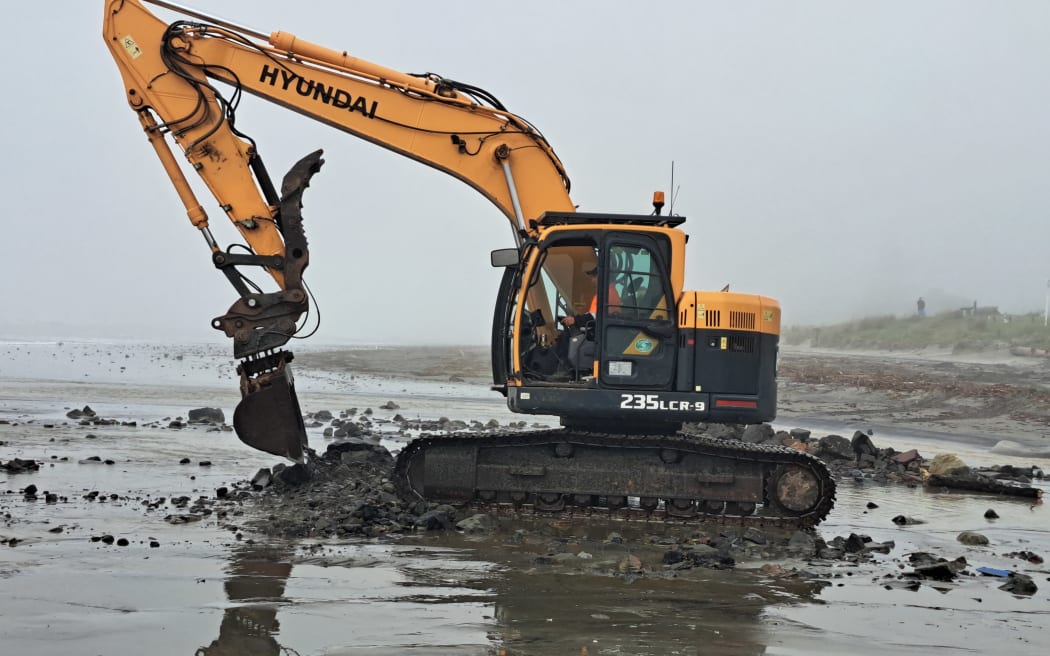 A digger cleaning up Waihi Beach in Bay of Plenty after flash flooding.