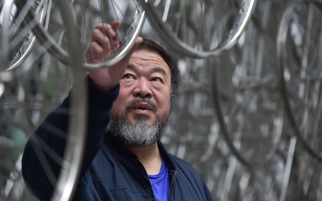 Chinese artist Ai Weiwei touches his sculpture 