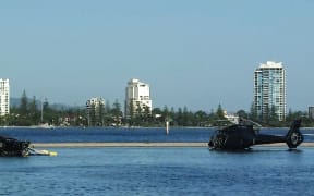 In this handout photo taken and released on January 3, 2023 two helicopters rest in water after colliding in mid-air in Gold Coast on January 2, killing four.