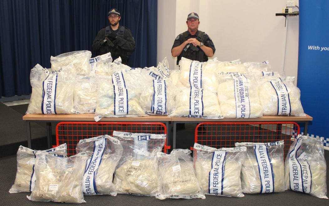 Officers stand near packages containing illicit drugs during a press conference in Sydney on 29 November 2014.