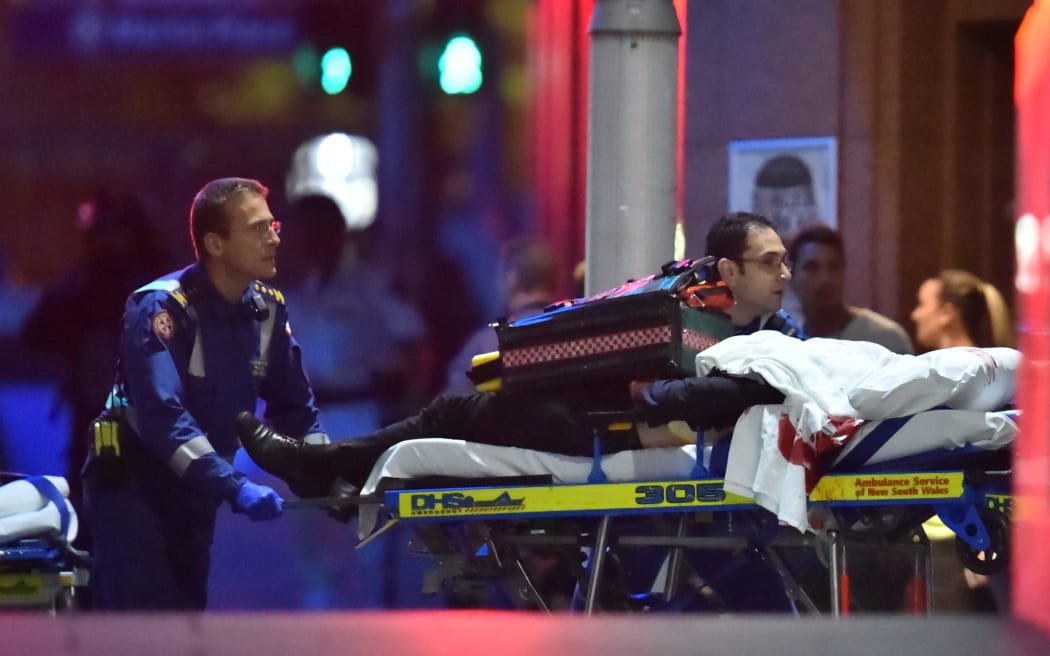 Paramedics take a person on a stretcher out of the Lindt cafe in Sydney's Martin Place.
