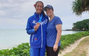 Anne Cairns with Pacific Games medal from Va'a race alongside supportive sister Bridget Cairns at the 2019 Pacific Games