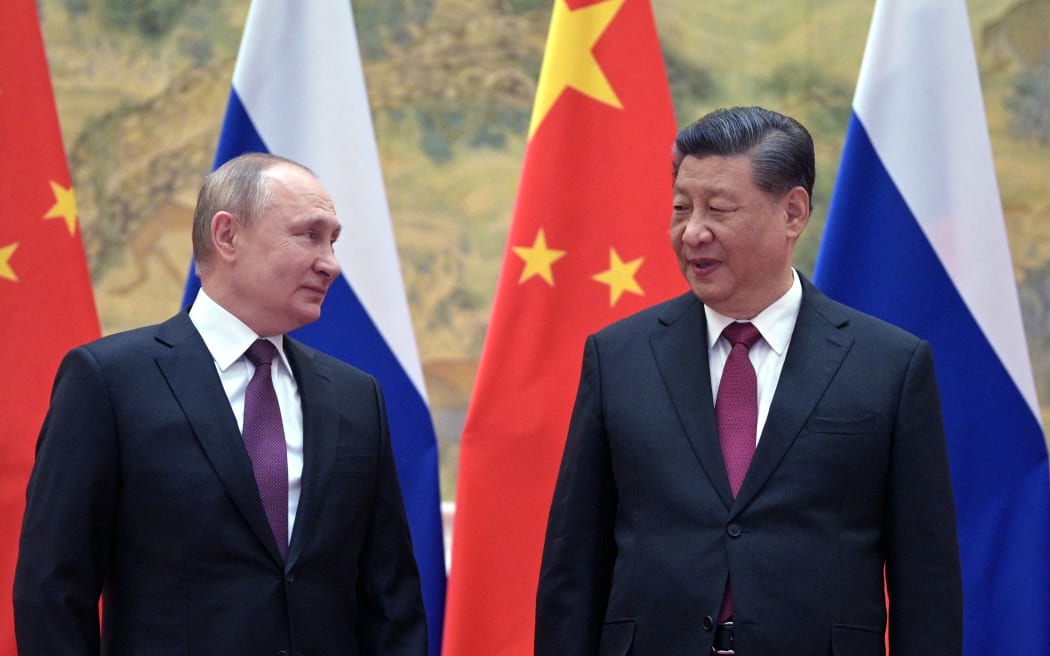 Russian President Vladimir Putin (L) and Chinese President Xi Jinping pose for a photograph during their meeting in Beijing, on 4 February 2022.