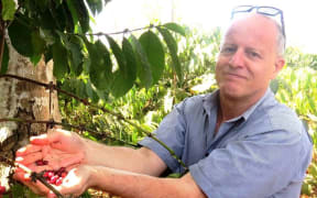Jonathan Schwass holding coffee beans in Timor Leste.