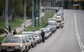 Local residents wait in line with their car to fill up with liquefied natural gas near a petrol station in Kramatorsk, eastern Ukraine, on April 21, 2022.