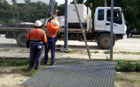 Workers removing fences from the Manus Island detention centre.