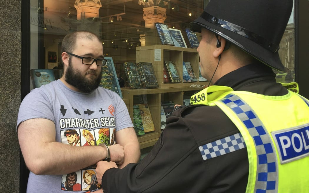 Paul Crowther speaks to police after Brexit Party leader Nigel Farage was hit with a milkshake during a campaign rally in Newcastle, England, Monday May 20, 2019.