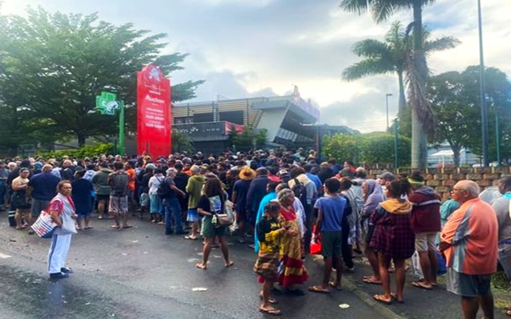 A large crowd in front of a supermarket in New Caledonia's capital.