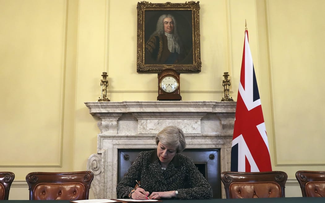FILE - In this Tuesday March 28, 2017 file photo Britain's Prime Minister Theresa May, sitting below a painting of Britain's first Prime Minister Robert Walpole,