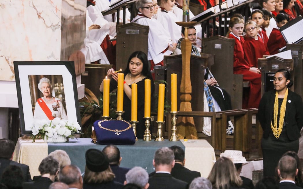 Representatives of various community groups light candles near the Queen's portrait during the Queen Elizabeth II state memorial service at the Wellington Cathedral of St Paul.