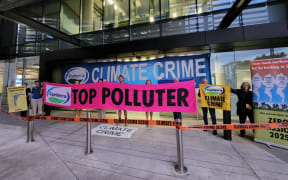 A small number of Extinction Rebellion protesters holding signs saying 'climate crime' and 'top polluter' blocked entrances to Fonterra's head office in central Auckland on Thursday 23 February 2023.