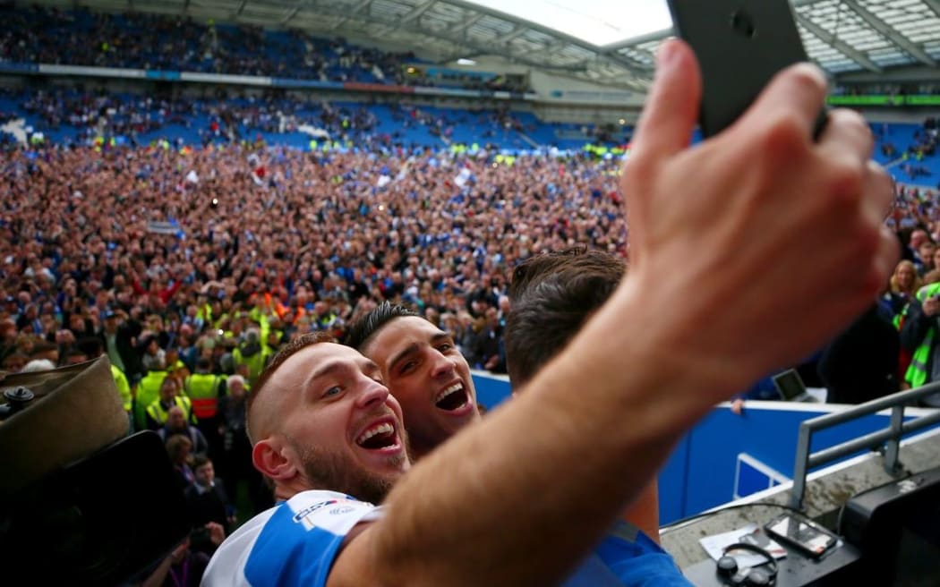 Brighton and Hove Albion players celebrate their promotion to the English Premier League.
