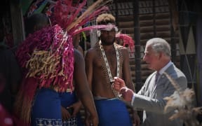 Prince Charles speaks with traditional dancers in Solomon Islands.