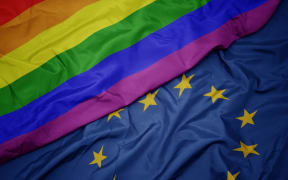 waving colorful flag of european union and gay rainbow flag .macro