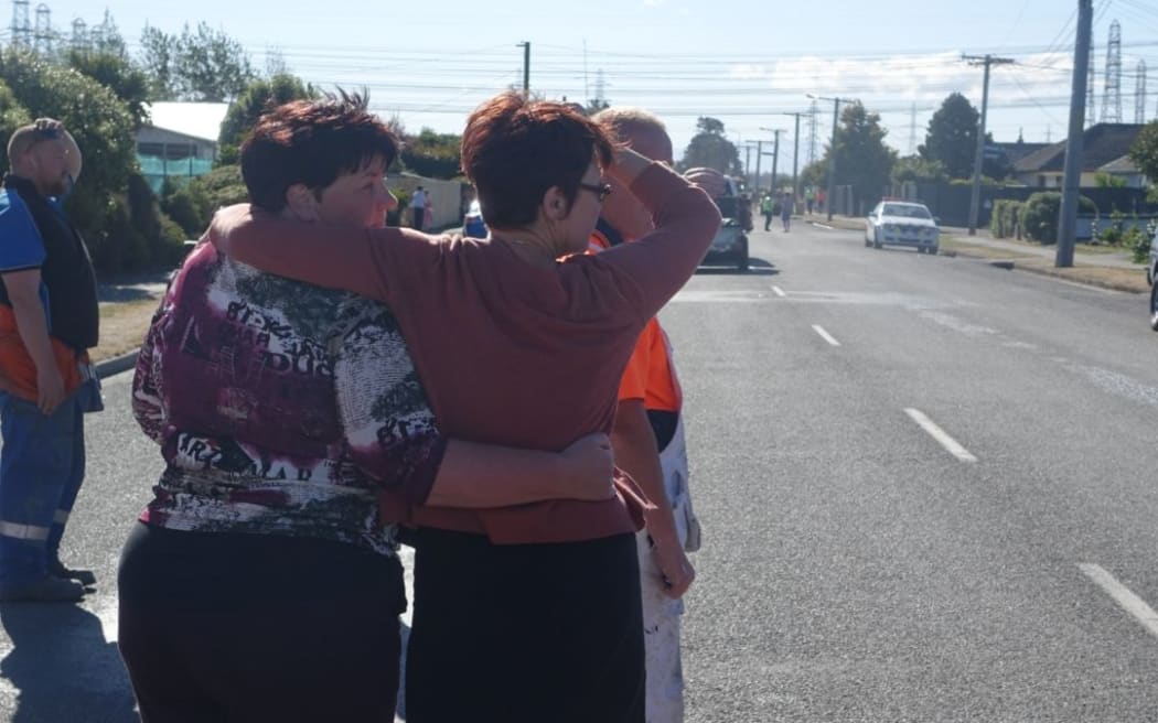 Neighbours in Roberts Road, Christchurch,  where two homes have been damaged by a blaze comfort each other at the cordon at the end of their street.