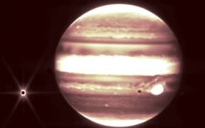 Jupiter's iconic Great Red Spot appears white in this infrared image from the James Webb Telescope.