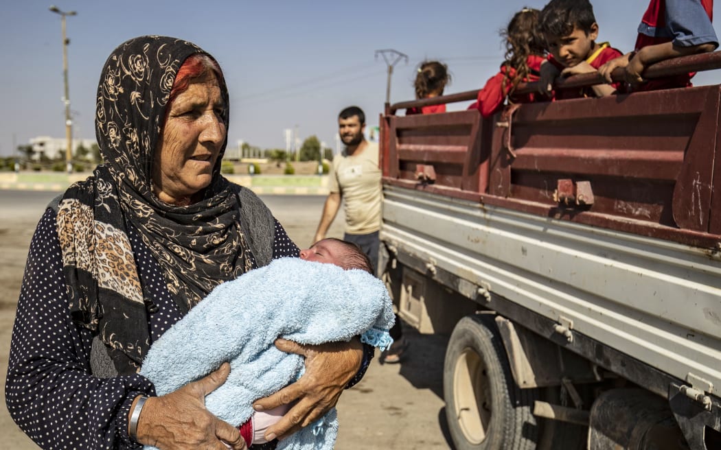 Syrian Arab and Kurdish civilians arrive to Tall Tamr town, in the Syrian northwestern Hasakeh province, after fleeing Turkish bombardment on the northeastern towns along the Turkish border on October 10, 2019.