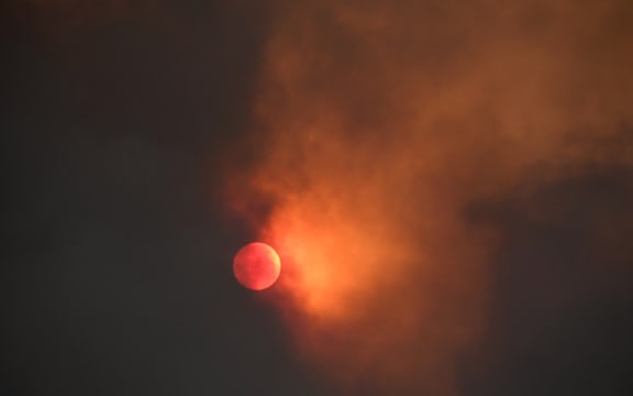 The sun is seen behind smoke from the Bobcat fire rising above in the Angeles National Forest above Duarte, California on 7 September, 2020.